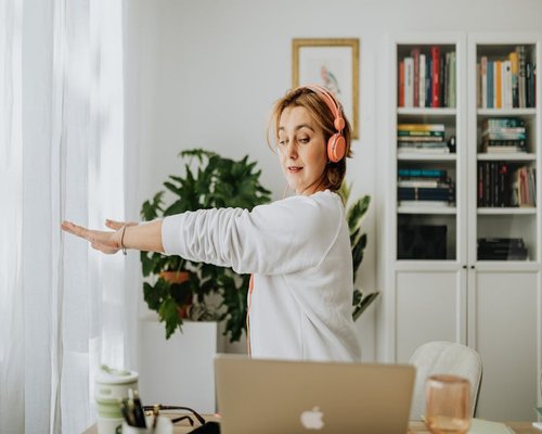 Person stretching arms behind back at office desk