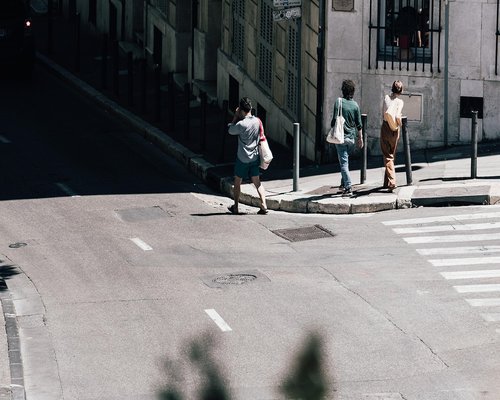 Legs of a person walking on a city pavement covered with leaves